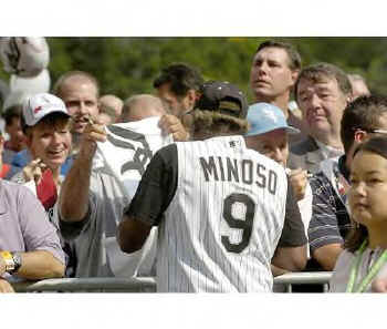 Minoso signs autographs.