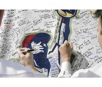 Fans sign a large White Sox poster.